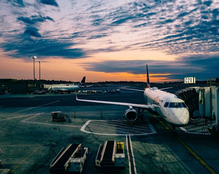 white airplane near trailers during sunset
